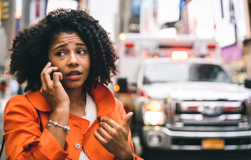 Woman calling police to file a report after a car accident.