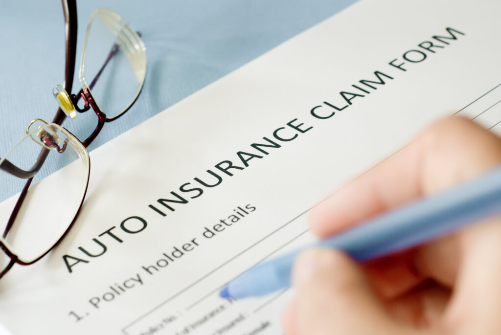 Person filling out insurance claim form after being injured in a vehicle accident. - Saladino & Schaaf, PLLC - Vehicle accident attorneys