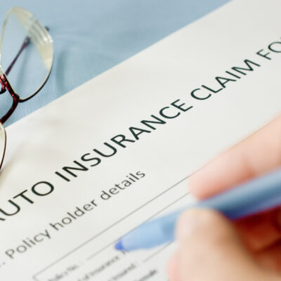 Person filling out insurance claim form after being injured in a vehicle accident. - Saladino & Schaaf, PLLC - Vehicle accident attorneys