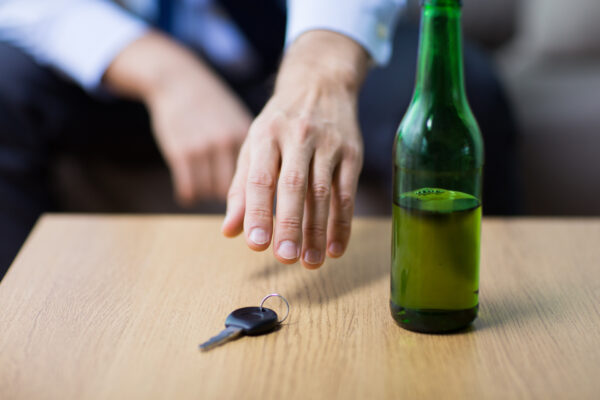 Man whose been drinking a beer reaching for car keys - Paducah injury lawyer, Saladino & Schaaf
