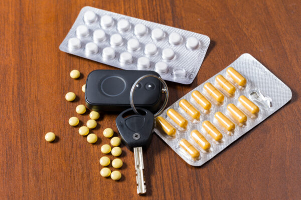 Illegal pills and car keys on a table indicating that the driver in impaired.