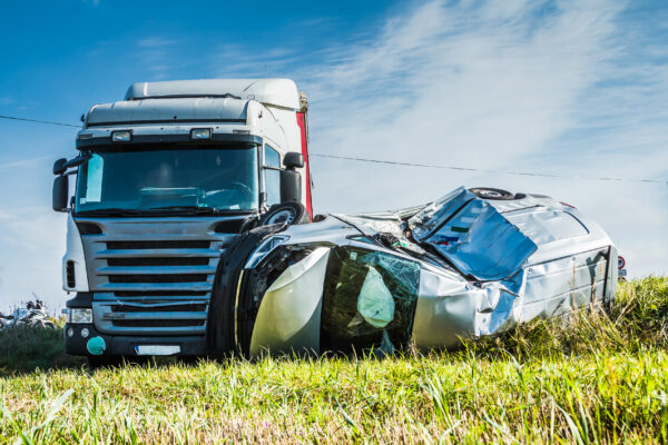 Car with severe damage after a collision with a semi-truck.