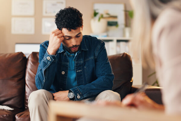 Man experiencing PTSD caused by a car crash speaking with therapist.