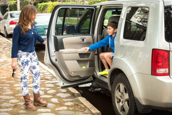 Child getting out of car at a school drop off line.